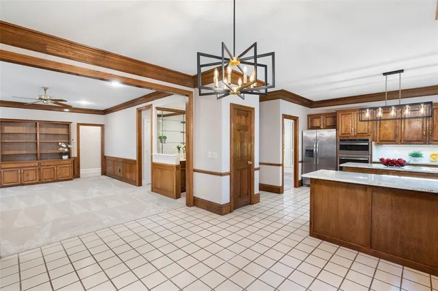 a view of a kitchen with stainless steel appliances kitchen island granite countertop a refrigerator and a stove