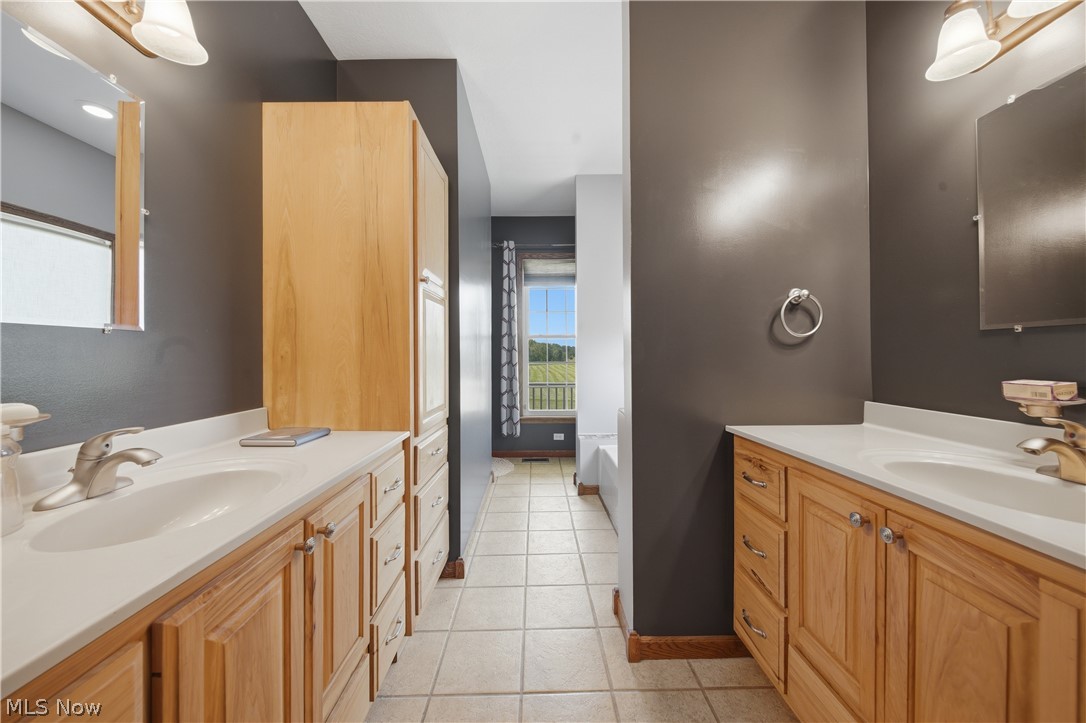 12159 Lawndell Road Southwest Beach City, OH 44608 - Photo 20 of 49 Bathroom featuring dual wood-finish vanities with integrated sinks, ample cabinetry, and tile flooring