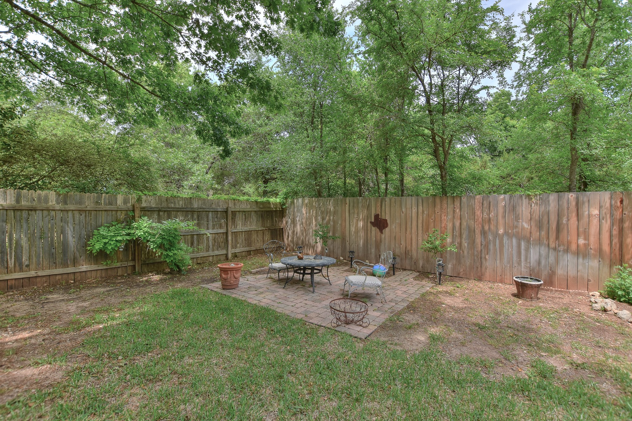 1609 Colton Way Cedar Park, TX 78613 - Photo 18 of 24 A private, verdant yard with a brick patio, perfect for outdoor relaxation.