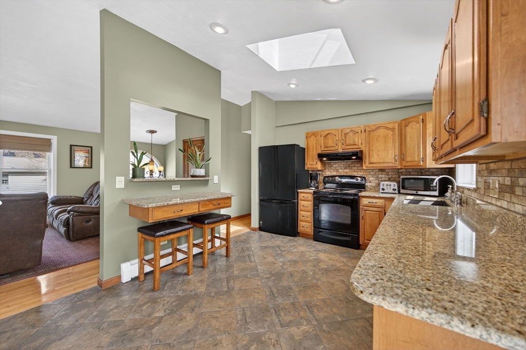 1079 Langley Street Fall River, MA 02720 - Photo 11 of 40 a kitchen with stainless steel appliances granite countertop a refrigerator a sink a stove and island