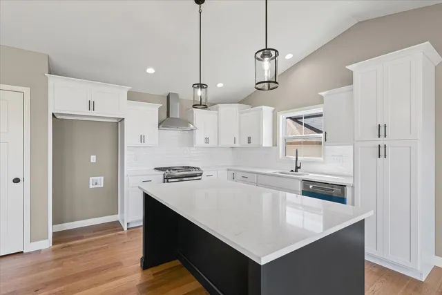 a kitchen with stainless steel appliances a stove a sink and a refrigerator