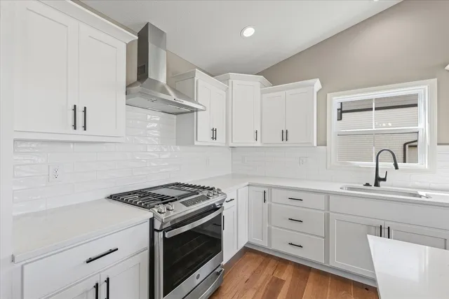 a kitchen with white cabinets and appliances