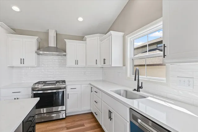 a kitchen with cabinets appliances a sink and a window