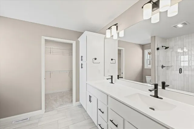 a bathroom with a double vanity sink mirror and shower