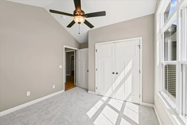 a view of a hallway with closet and a chandelier fan