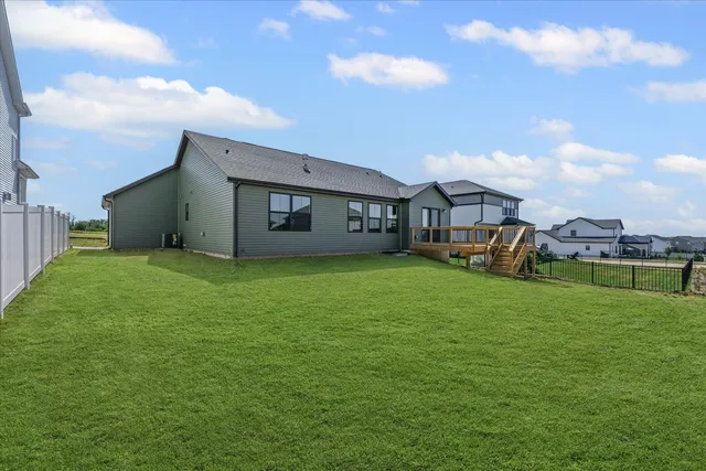 a view of a house with a big yard and large trees
