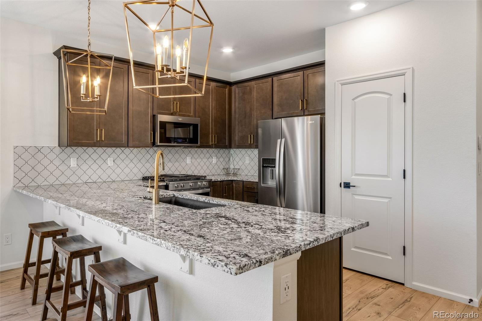 306 Rodden Drive Erie, CO 80516 - Photo 11 of 49 a kitchen with stainless steel appliances granite countertop a sink refrigerator and microwave