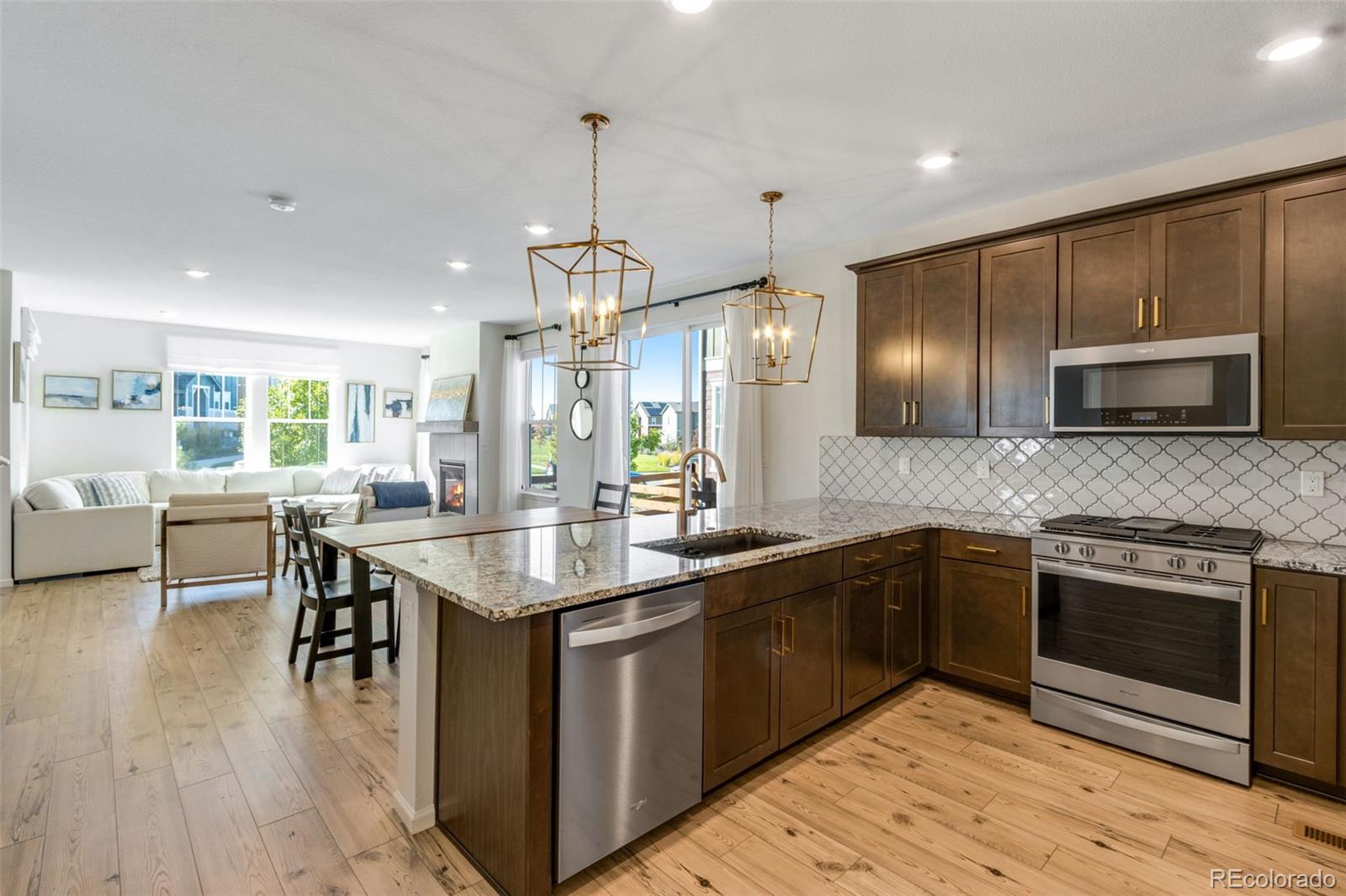 306 Rodden Drive Erie, CO 80516 - Photo 12 of 49 a kitchen with granite countertop stainless steel appliances cabinets a sink and a wooden floors