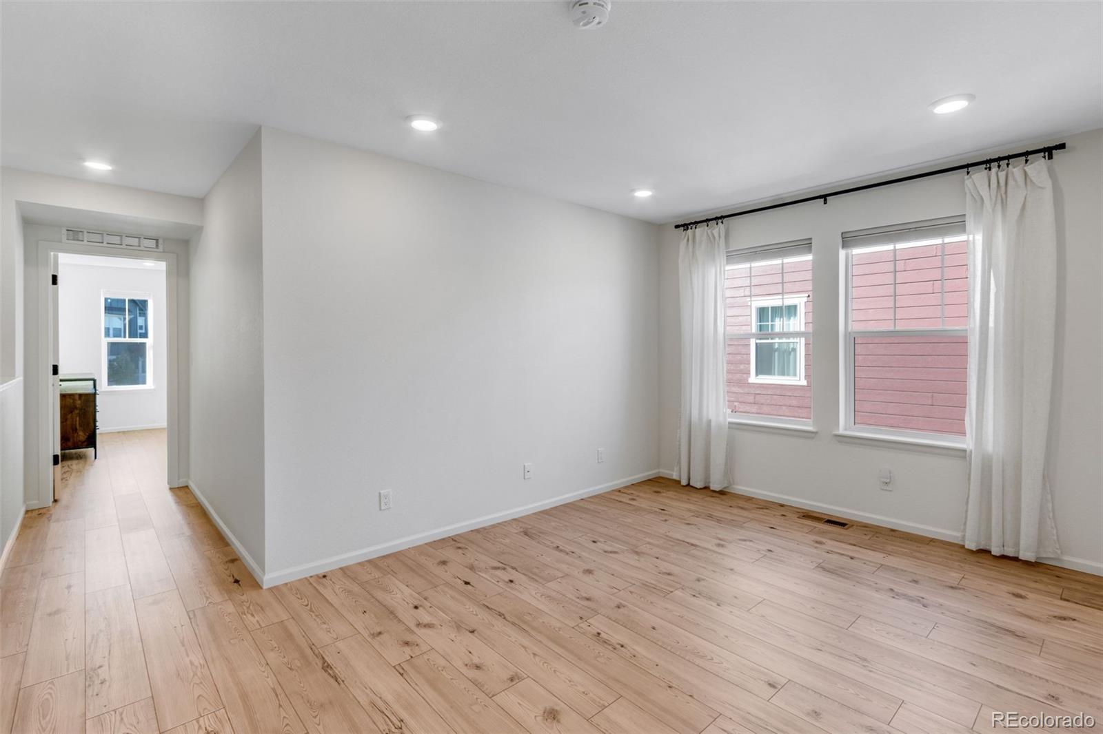 306 Rodden Drive Erie, CO 80516 - Photo 14 of 49 wooden floor in an empty room with a window