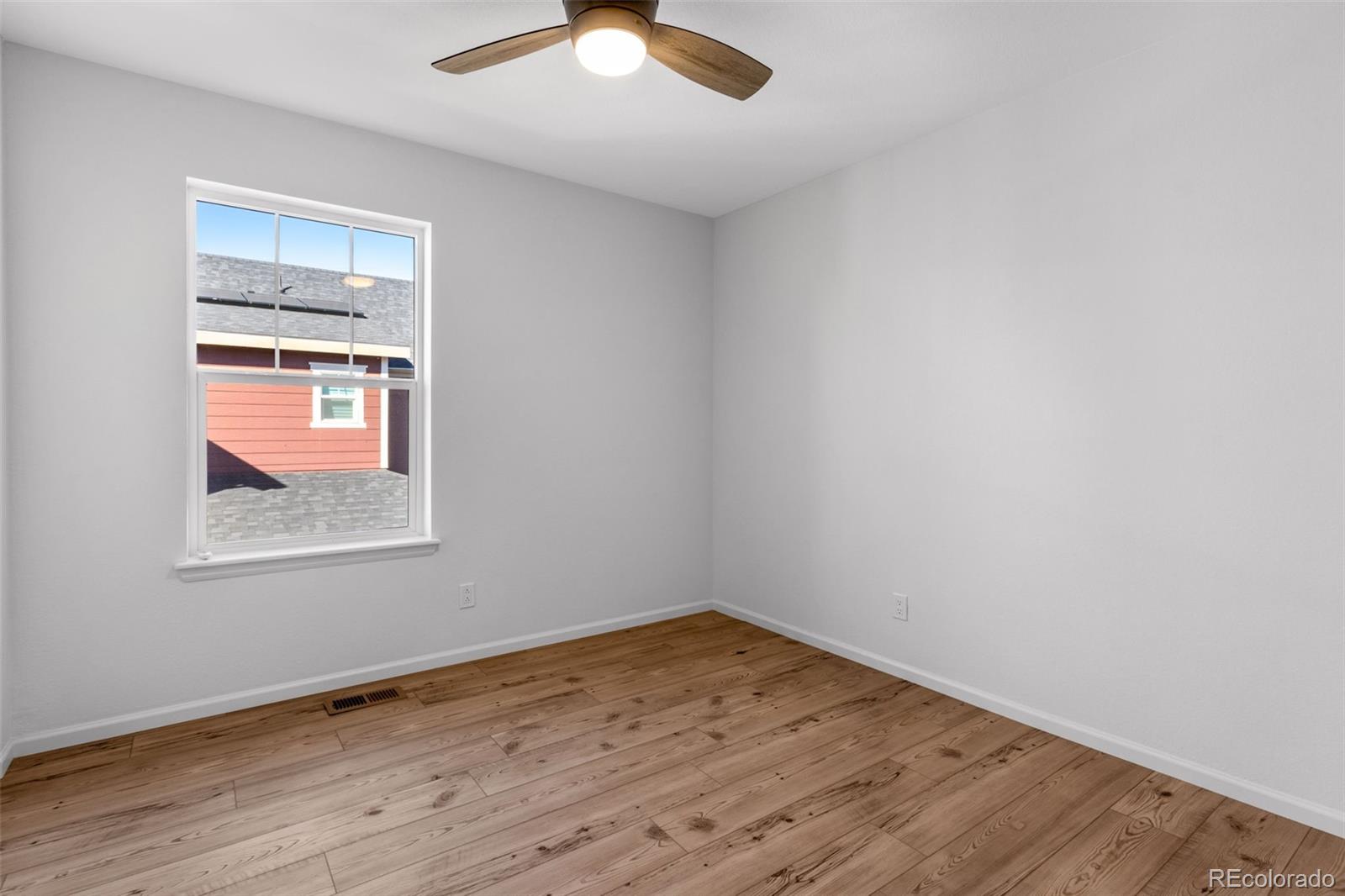 306 Rodden Drive Erie, CO 80516 - Photo 22 of 49 an empty room with wooden floor and windows