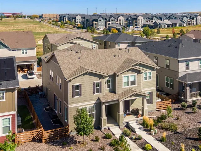 an aerial view of residential houses with outdoor space and ocean view