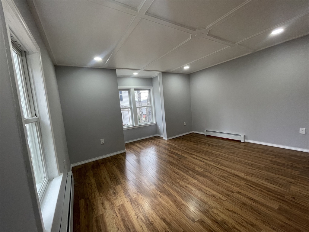 59 High Street Warren, MA 01083 - Photo 17 of 42 an empty room with wooden floor and windows