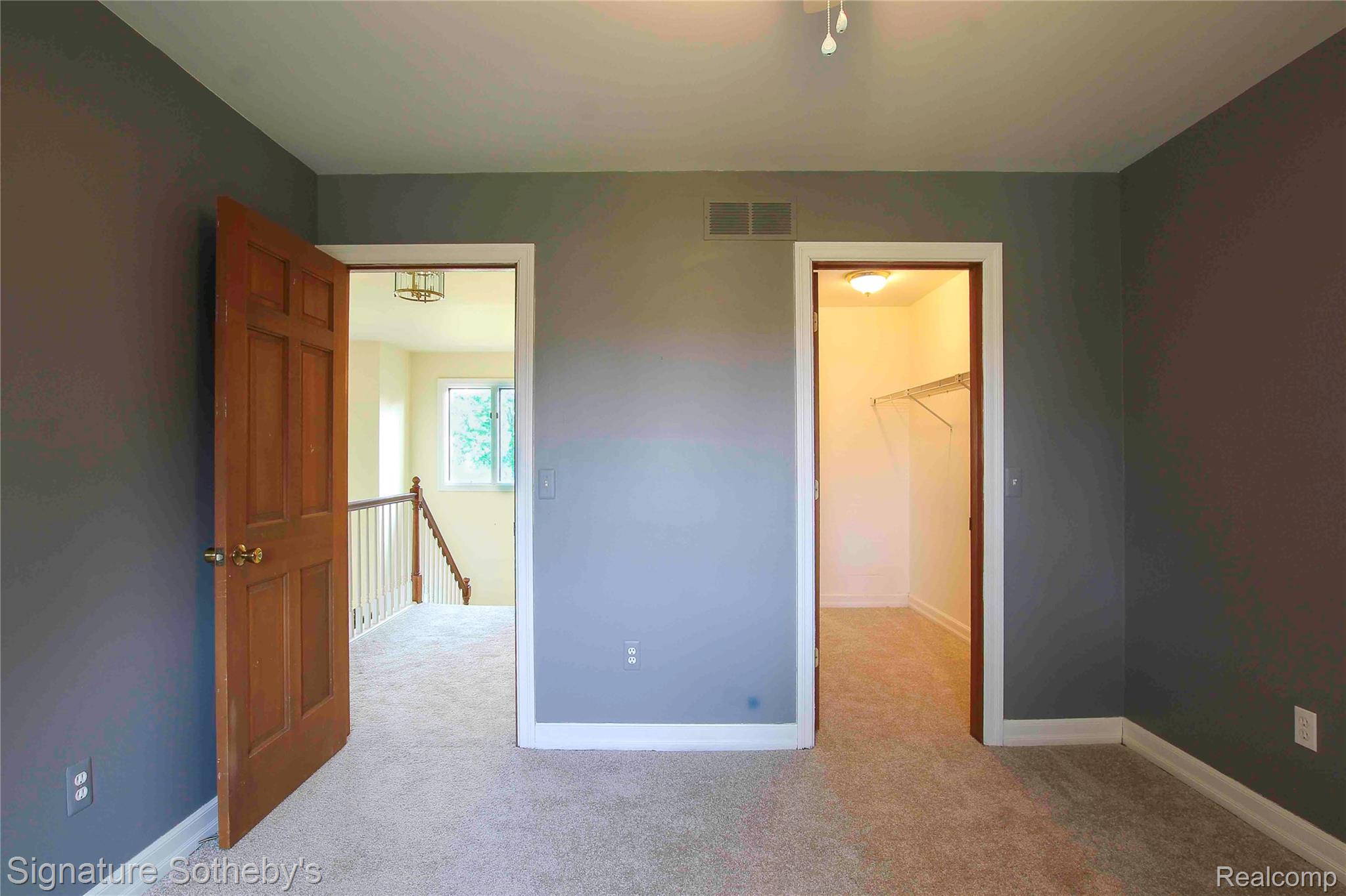 3131 Smugglers Ridge Walled Lake, MI 48390 - Photo 24 of 35 Room featuring two doorways, one opening to a carpeted hallway and the other to a walk in closet.