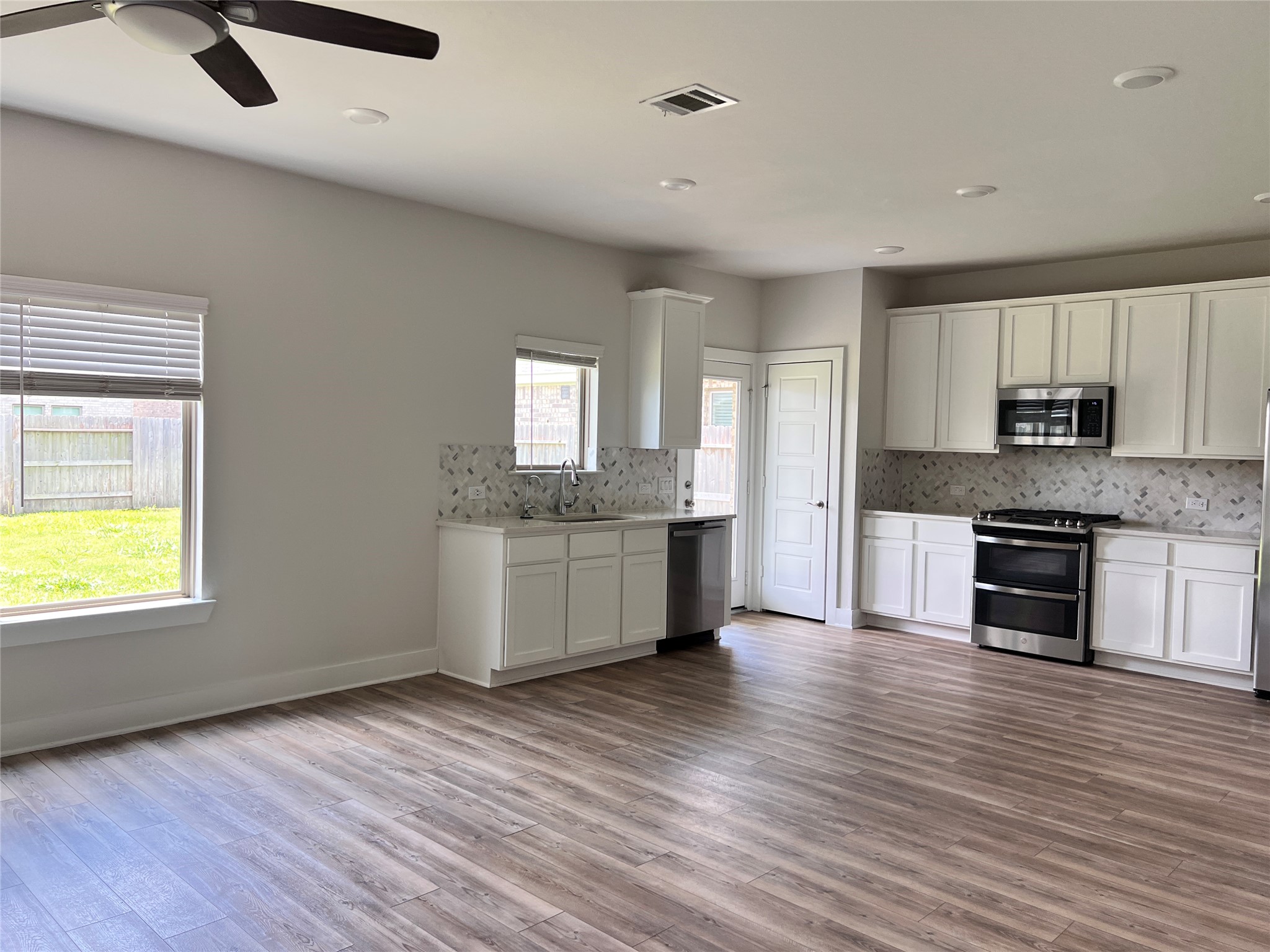 10638 Whitejacket Conroe, TX 77385 - Photo 20 of 25 a large kitchen with a wooden floor and white stainless steel appliances