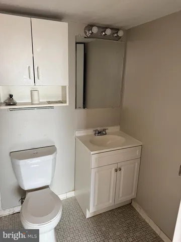 a bathroom with a toilet sink and mirror
