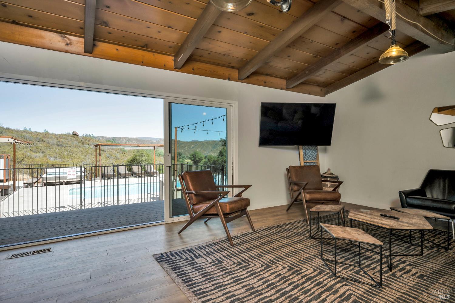 500 Old Long Valley Road Clearlake Oaks, CA 95423 - Photo 52 of 83 a living room with furniture a flat screen tv and a floor to ceiling window