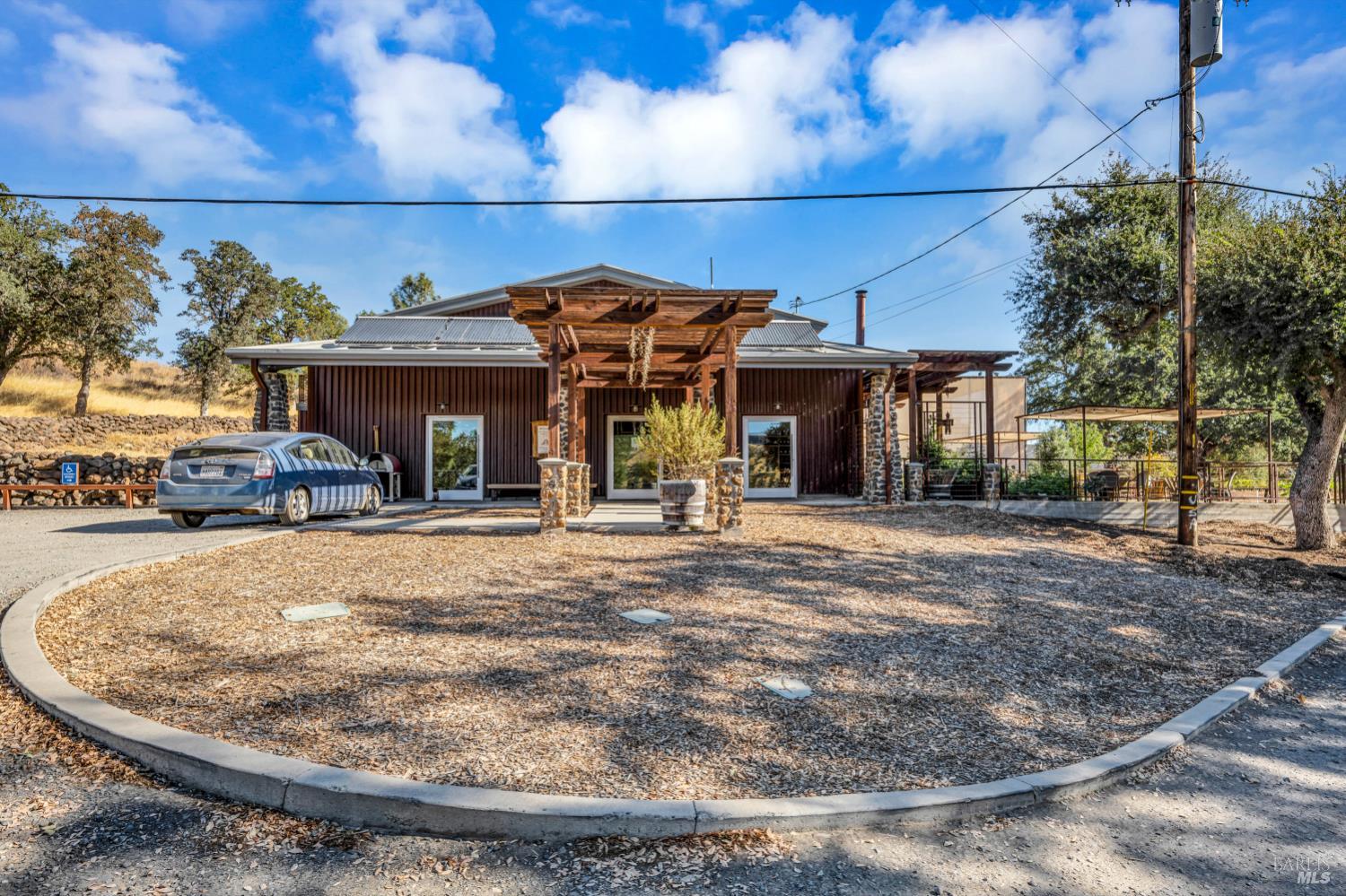 500 Old Long Valley Road Clearlake Oaks, CA 95423 - Photo 77 of 83 a view of a white house with large windows and a table and chairs under an umbrella