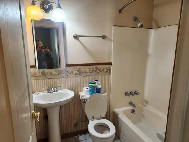 a bathroom with a sink mirror toilet and bathtub