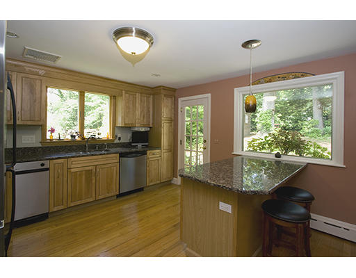26 Tomahawk Road Arlington, MA 02474 - Photo 11 of 30 a kitchen with kitchen island granite countertop a sink cabinets and a large window