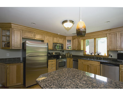 26 Tomahawk Road Arlington, MA 02474 - Photo 12 of 30 a kitchen with stainless steel appliances granite countertop a sink refrigerator and cabinets