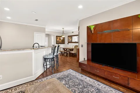 a living room with furniture a flat screen tv and kitchen view