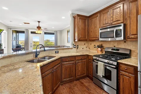 a kitchen with stainless steel appliances granite countertop a sink stove and microwave