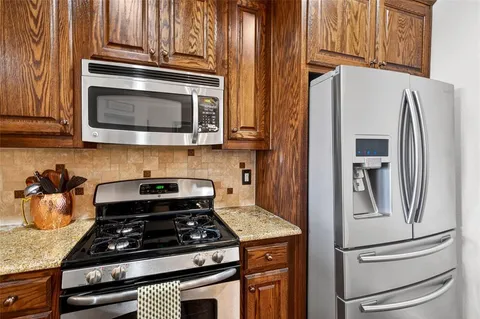 a kitchen with granite countertop stainless steel appliances and wooden cabinets
