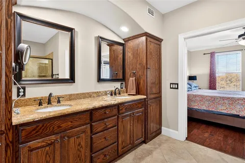 a en suite bathroom with a double vanity sink and a mirror