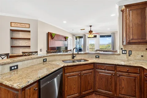 a kitchen with stainless steel appliances granite countertop a sink stove and cabinets