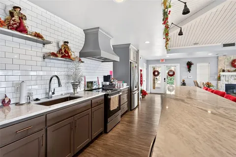 a large kitchen with stainless steel appliances granite countertop a sink and cabinets