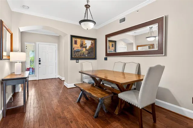 a dining room with wooden floor and a chandelier