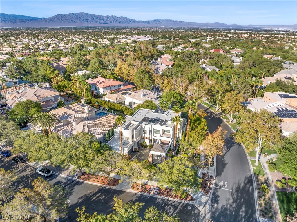 2000 Grouse Street Las Vegas, NV 89134 - Photo 82 of 89 An aerial panorama reveals a contemporary residence nestled among lush landscaping with distant mountains.