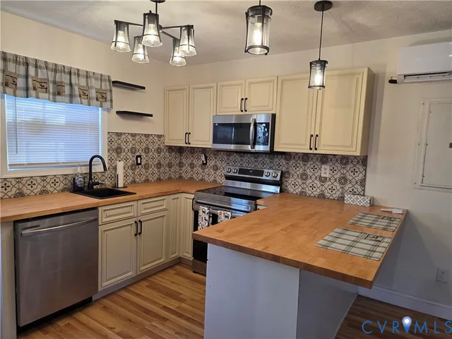 a kitchen with stainless steel appliances granite countertop a sink a stove and a refrigerator