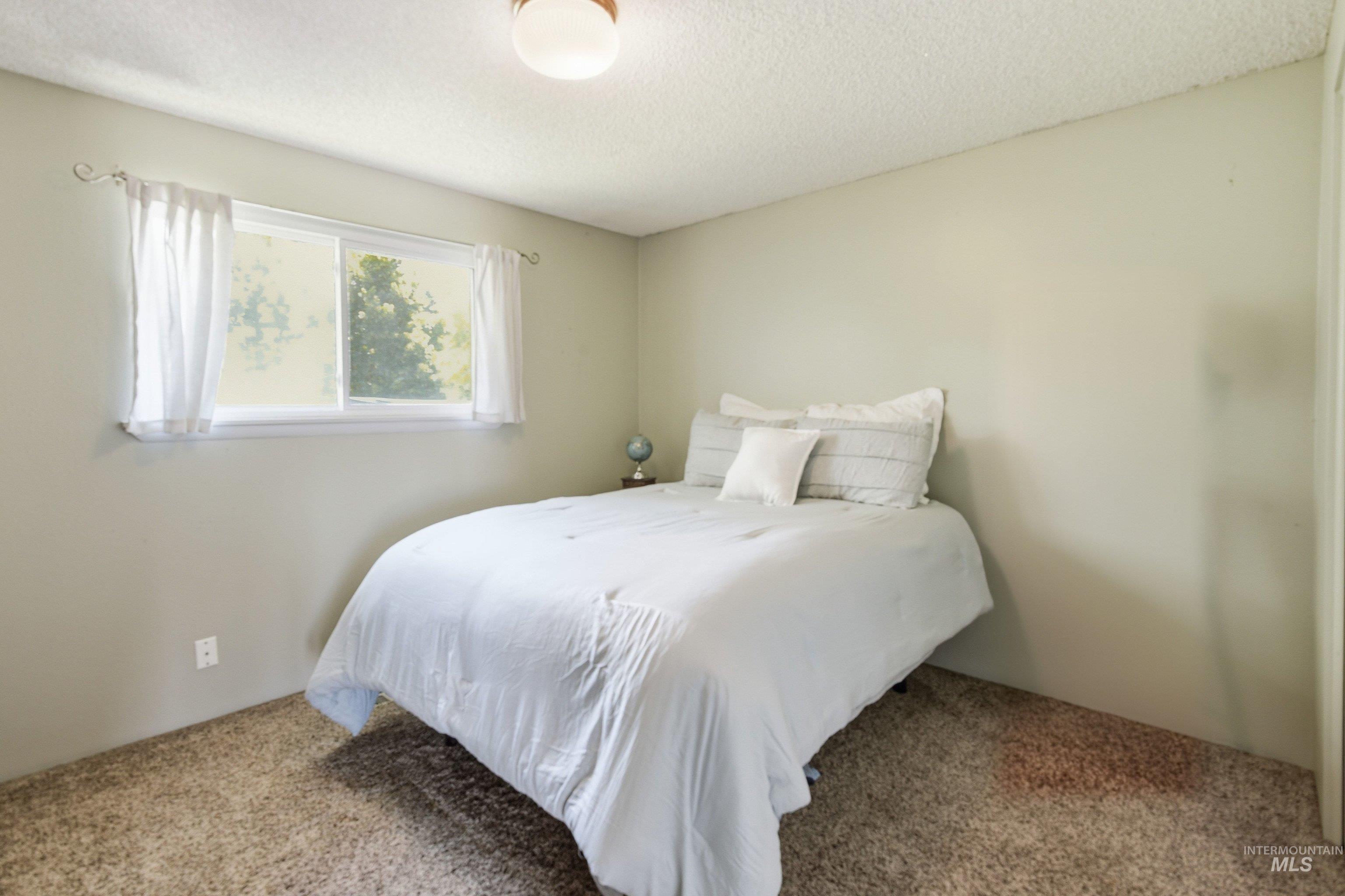 15095 David Street Caldwell, ID 83607 - Photo 24 of 39 Carpeted room featuring light-toned walls and a window with white curtains