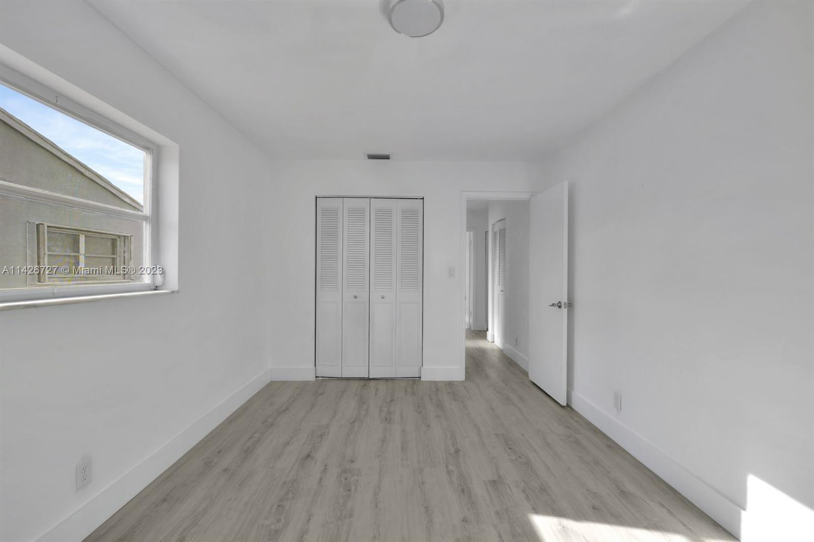 4964 Northwest 48th Way Tamarac, FL 33319 - Photo 12 of 16 a view of an empty room with wooden floor and windows