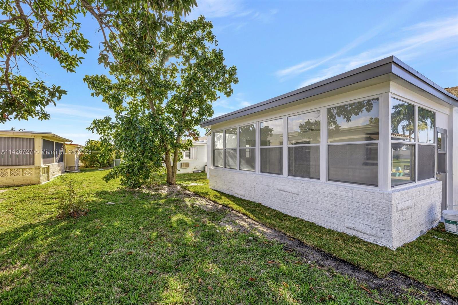 4964 Northwest 48th Way Tamarac, FL 33319 - Photo 14 of 16 a front view of a house with a yard