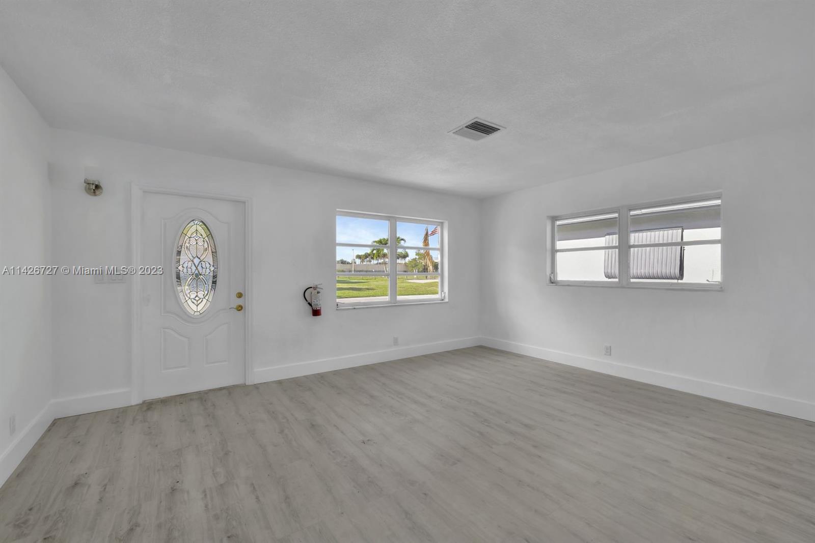 4964 Northwest 48th Way Tamarac, FL 33319 - Photo 4 of 16 a view of room with wooden floor and window