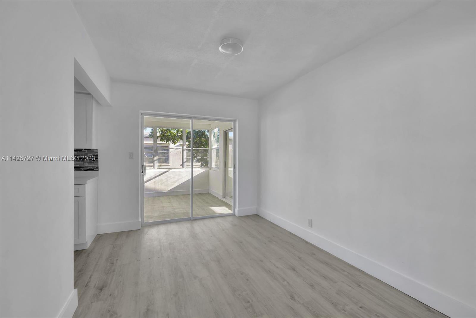 4964 Northwest 48th Way Tamarac, FL 33319 - Photo 6 of 16 wooden floor in an empty room with a window