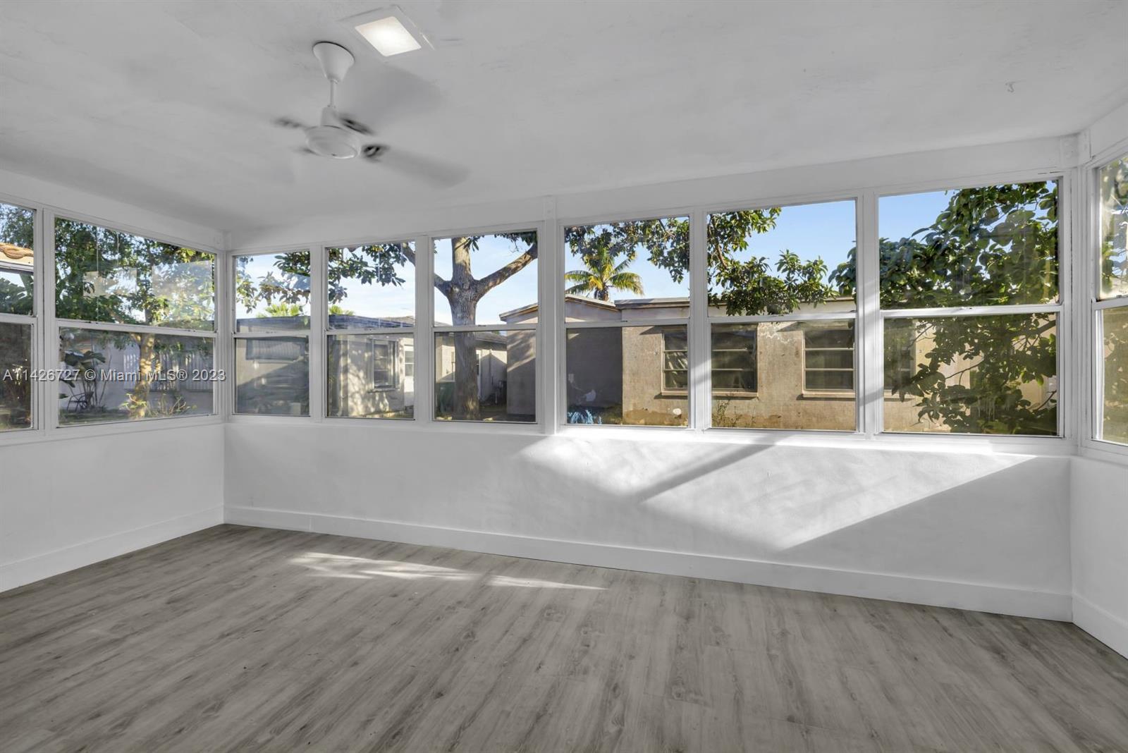 4964 Northwest 48th Way Tamarac, FL 33319 - Photo 8 of 16 a view of an empty room with a window and wooden floor