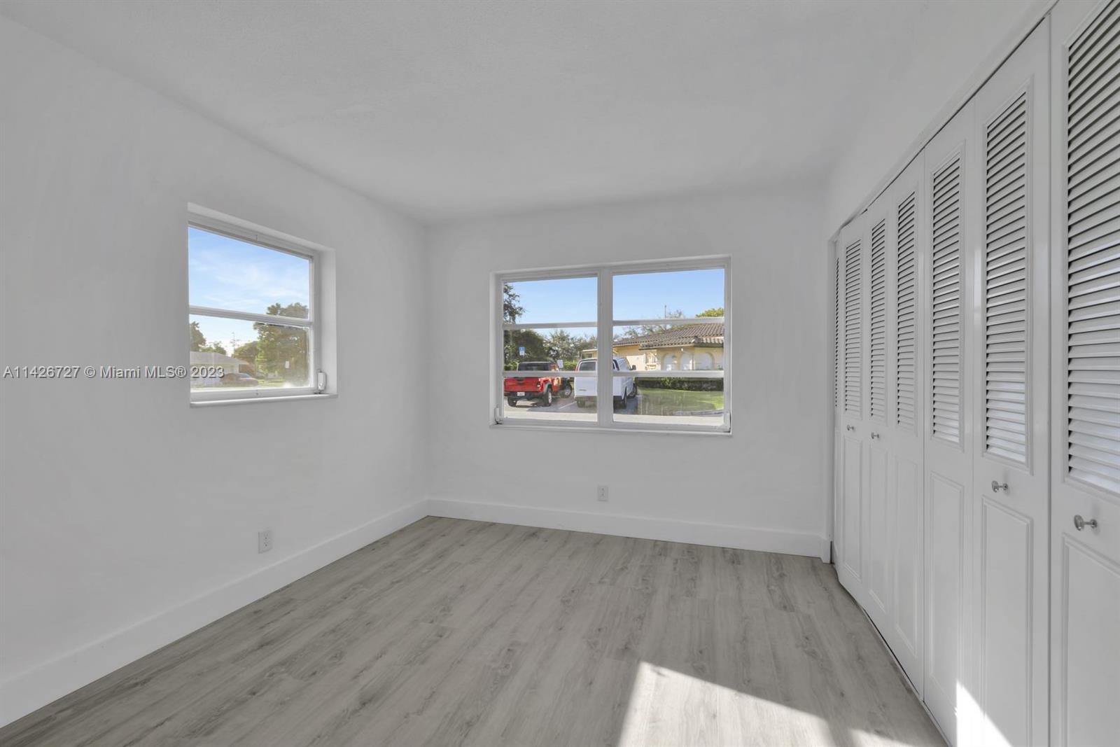 4964 Northwest 48th Way Tamarac, FL 33319 - Photo 10 of 16 an empty room with wooden floor and window