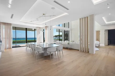 a living room with lots of white furniture and a painting on the wall