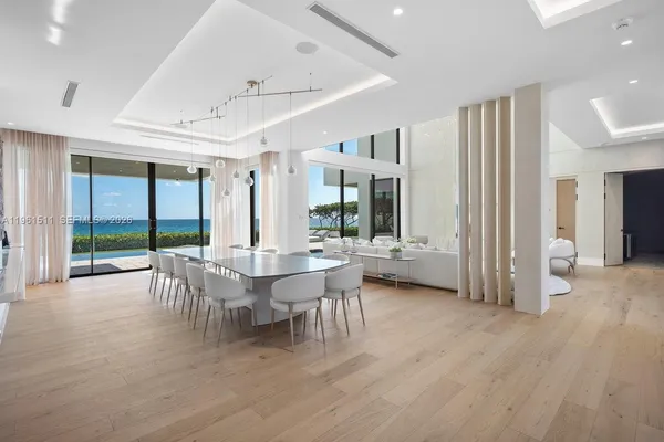 a living room with lots of white furniture and a painting on the wall