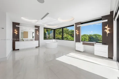 a spacious bedroom with a bed and a flat screen tv