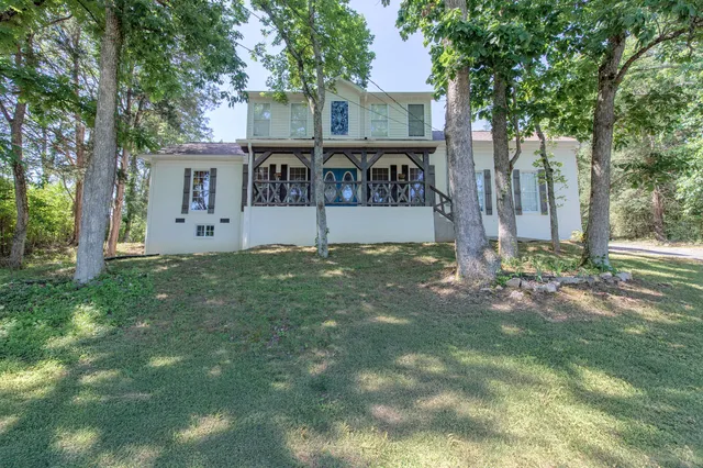 a view of house with backyard and trees
