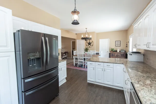 a kitchen with stainless steel appliances granite countertop a refrigerator and a stove top oven