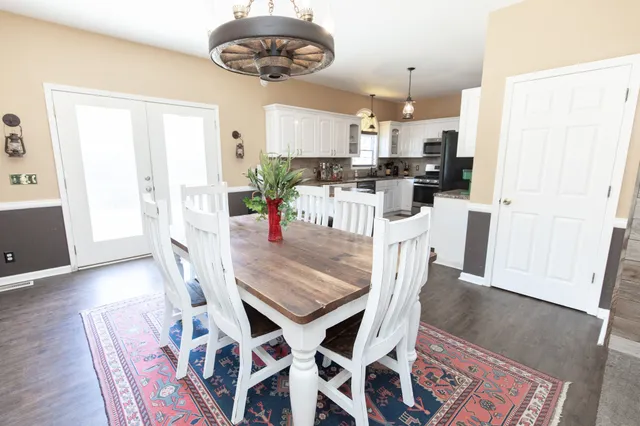 a dining room with stainless steel appliances kitchen island granite countertop furniture and wooden floor