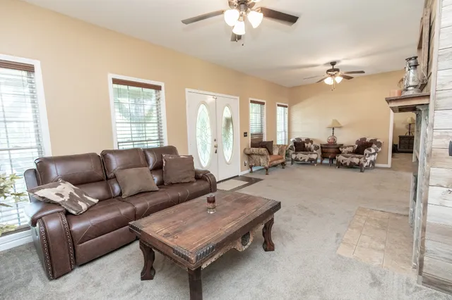 a living room with furniture a chandelier and a window