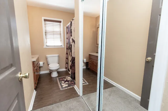 a bathroom with a sink toilet and window