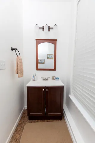 a bathroom with a granite countertop toilet a sink and mirror