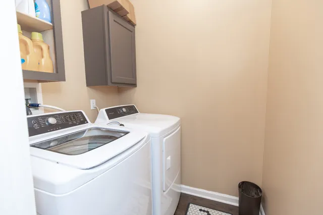a view of a white house with a yard and large tree